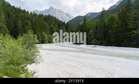 Photo of wonderful landscape of Triglav National Park in sunny day. Majestic Mangart Mount near Jasna lake. Wild area. Julian Alps, Gozd Martuljek, Sl Stock Photo