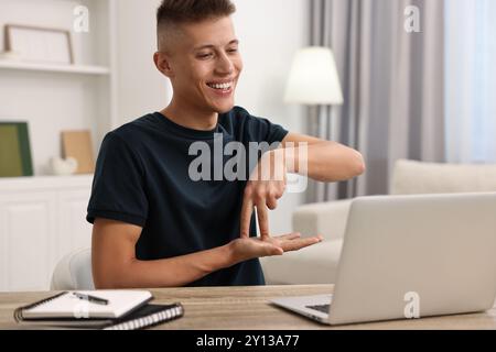 Young man using sign language during video call indoors Stock Photo