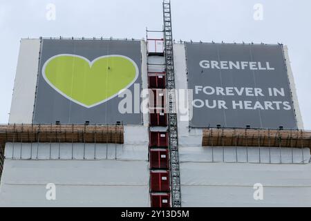 The top of Grenfell Tower covered by green hearts and the words, 'Forever in our hearts,' in memory of the 72 residents who perished in the fire. Stock Photo