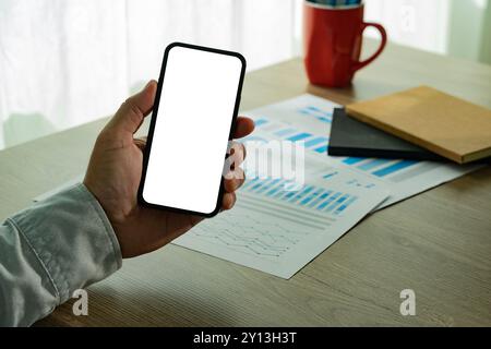 Top view Mockup image hand using a smartphone man Holding Cell Phone With Blank Screen Stock Photo