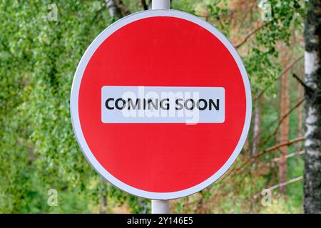 Conceptual coming soon symbol. Copy space. COMING SOON words written traffic is prohibited on the sign against the background of the forest Stock Photo