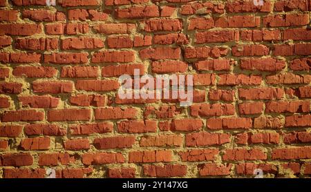 An old scratched red brick wall background. Close up. Stock Photo