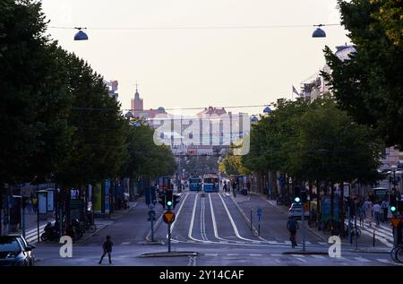 Busy Kungsportsavenyen in Göteborg downtown. Bustling road in the city with cablecars and people hurrying at the foot of the hill. Vastra Gotaland Stock Photo