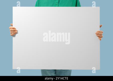Unrecognizable person holding white canvas with empty place for text in hands Stock Photo