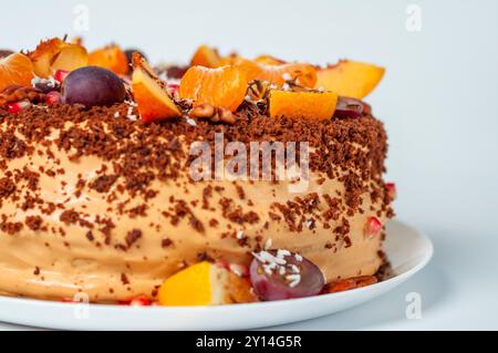 Close-up of a chocolate cake garnished with tangerines, grapes, and nuts. Stock Photo