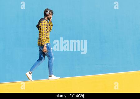 young black man with headphones walking Stock Photo