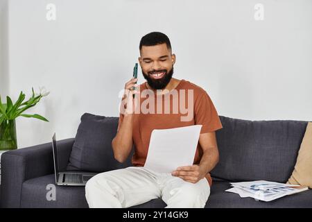 Happy man chatting on the phone while going through important documents. Stock Photo