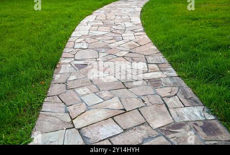 Stone curve path with green grass in a garden Stock Photo