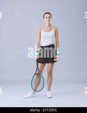 Portrait of a young athletic tennis player, she is standing and looking at camera, sports and competition concept, full length Stock Photo