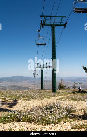 A green ski lift from atop Bald Mountain overlooking a valley at Deer Valley. Stock Photo