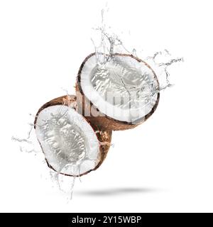 Fresh coconut water splashing from nut in air on white background Stock Photo