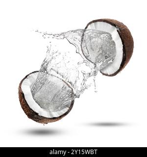 Fresh coconut water splashing from nut in air on white background Stock Photo