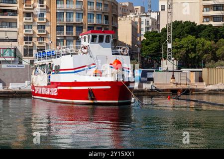 Valletta, Malta - August 23, 2019: Red white passenger ferry by Captain Morgan Cruises company is moored in Sliema on a sunny summer day Stock Photo