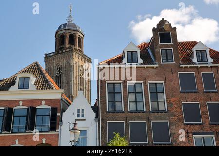 Historic medieval houses, located on the banks of the river Ijssel, in Deventer, Overijssel, Netherlands, with the bell tower of Lebuinus church Stock Photo