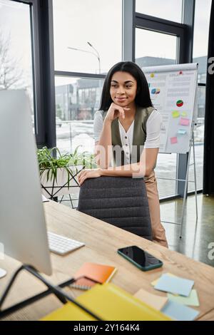 A focused woman engages in creative work at a contemporary desk. Stock Photo