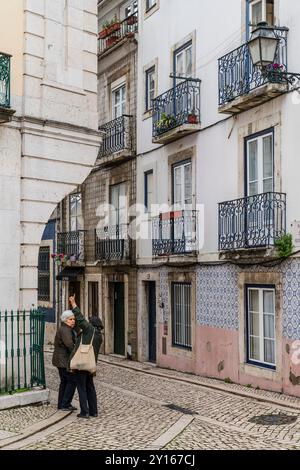 People watching in Lisbon, street photography - Sao Cristovao corner of streets on castle hill. Stock Photo