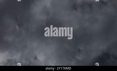 A thick layer of dark storm clouds looms overhead, signaling an impending thunderstorm that may bring heavy rain and strong winds to the area. Stock Photo