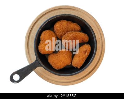 Crispy Chicken Nuggets in Rustic Cast Iron Skillet on Wooden Board. Stock Photo