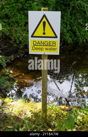 Danger deep water sign post with water behind Stock Photo - Alamy