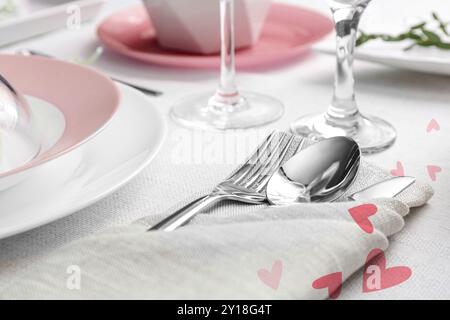 Table setting for romantic Valentine's day celebration. Plates, cutlery and hearts Stock Photo
