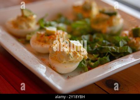 Avocado topped deviled eggs with salad Stock Photo