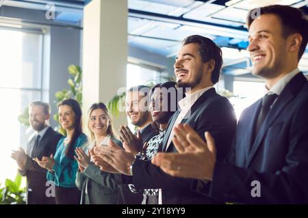 A diverse and enthusiastic audience is applauding the speaker, smiling with joy. Stock Photo