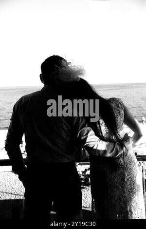 groom carries his bride in his arms through the old town Stock Photo