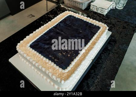 Elegant Dessert Delight - Dark Chocolate Sheet Cake with Creamy White Frosting and a Sophisticated Table Setting. Stock Photo