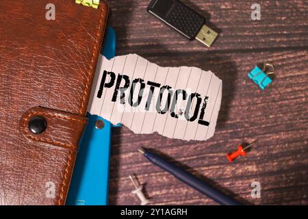 Business concept. Text PROTOCOL is written in a notebook in a composition with American hundred dollar bills and a pencil Stock Photo