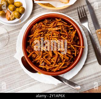 There is portion of Chinese noodles with chicken and vegetables in deep clay plate Stock Photo