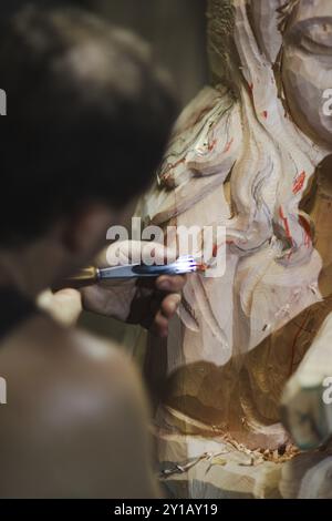 Detailed close-up of a hand using a carving tool on wood, revealing artistic precision Stock Photo