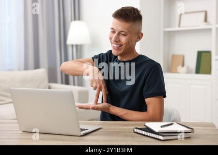 Young man using sign language during video call indoors Stock Photo
