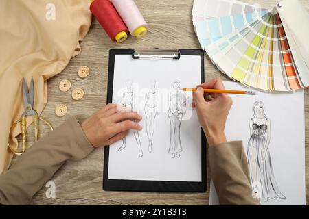 Fashion designer drawing sketch of stylish clothes at wooden table, top view Stock Photo