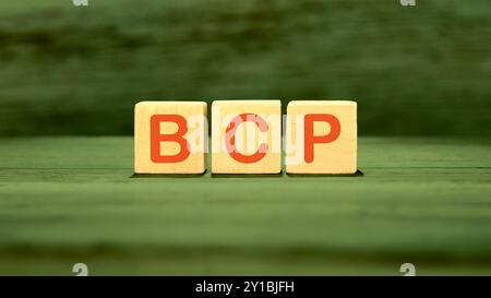 BCP Business Continuity Plan. BCP assembled from wooden cubes on a green background Stock Photo