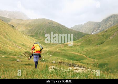 Panorama hiking caucasian man and woman hikers group walking in mountains nature landscape banner. Panoramic portrait of couple trekking in summer out Stock Photo