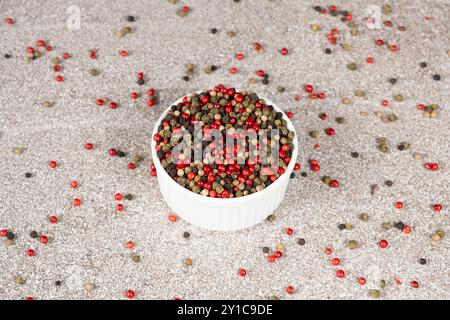 Multicolored peppercorns on a stone gray background Stock Photo