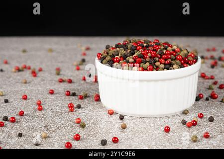 Multicolored peppercorns on a stone gray background Stock Photo