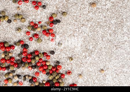 Multicolored peppercorns on a stone gray background Stock Photo