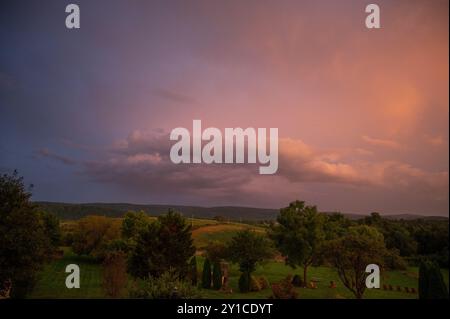 Gorgeous pink and blue sky at sunset over rolling hills Stock Photo