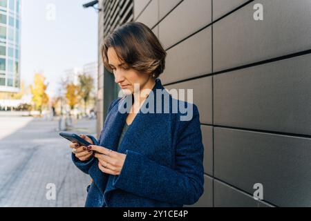 young woman using smartphone in urban setting Stock Photo