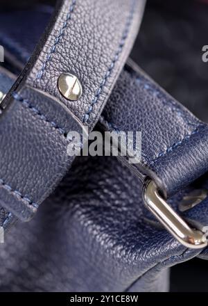 Part of a blue leather bag on a black background. Leather goods. Stock Photo