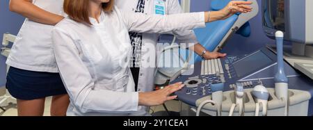 Three doctors discuss the results of ultrasound examinations of a patient in the hospital Stock Photo