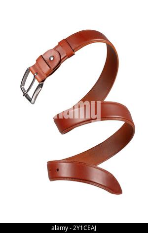 Brown leather belt with metal buckle coiled in a close-up on a white background. Stock Photo