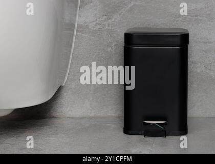 Compact Black Pedal Trash Bin in Minimalist Bathroom Stock Photo