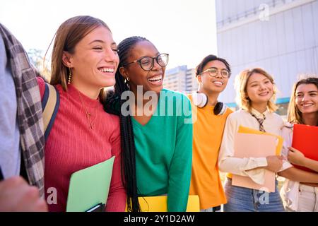 Side view cheerful student group multiracial classmates people standing hugging together for photo.  Stock Photo