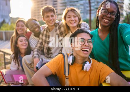 Happy multiracial classmates university students posing sitting together taking selfie photo outdoor Stock Photo