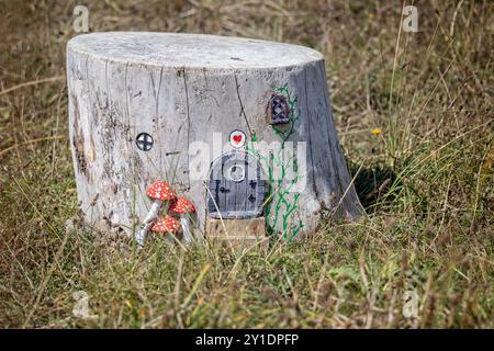 Miniature fairy house made from tree stump in field at Northam Burrows Country Park, Northam, Devon, UK on 3 September 2024 Stock Photo