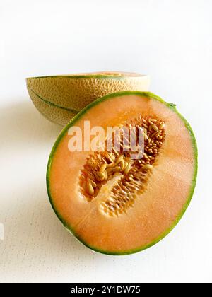 Cantaloupe melon cut in half isolated on a white background. Healthy and vegetarian food. Directly above. Copy space. Stock Photo