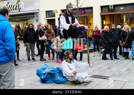 Germany, Düsseldorf - December 21, 2013 - A street performer levitating above the ground while another performer sits below, both dressed in elaborate Stock Photo