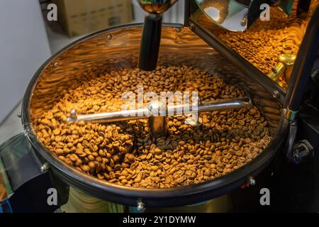 Coffee beans are roasted in the roasting machine. Coffee grinding and roasting Stock Photo